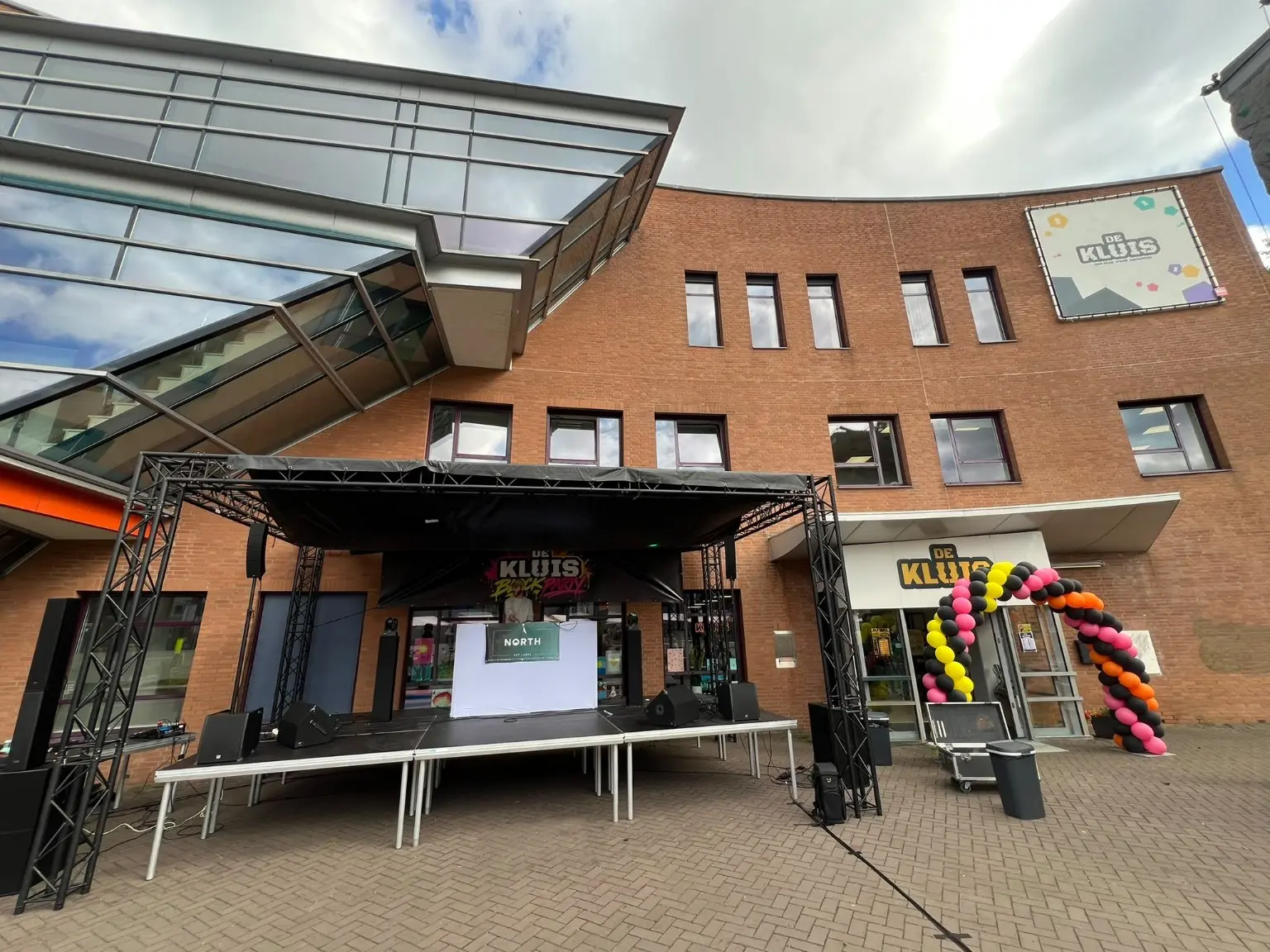 Overzicht van het Block Party-podium voor De Kluis in Assen, naast de entree met ballonnenboog