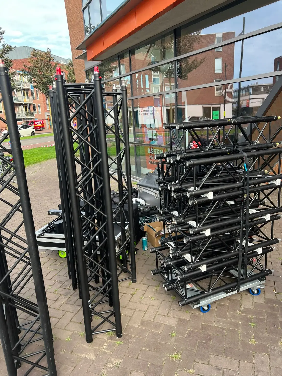 Zwarte trussdelen op transportkarren tijdens de opbouw bij De Kluis